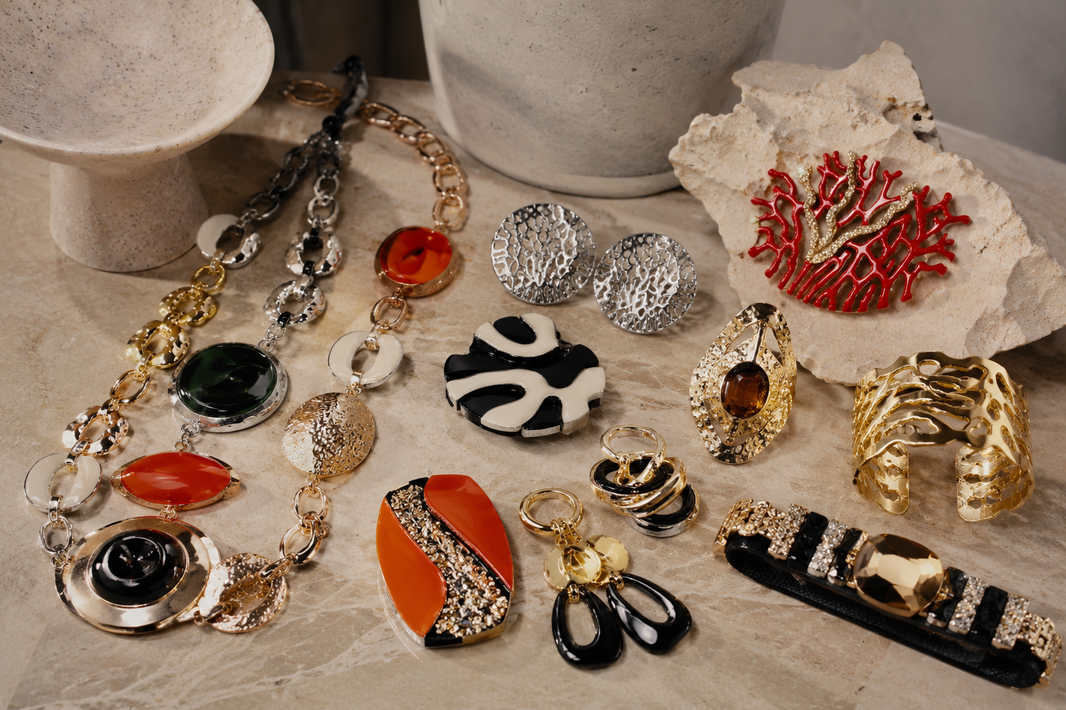 Premium Italian costume jewelry with bold necklaces, sculptural earrings, bracelets and statement accessories arranged on stone.